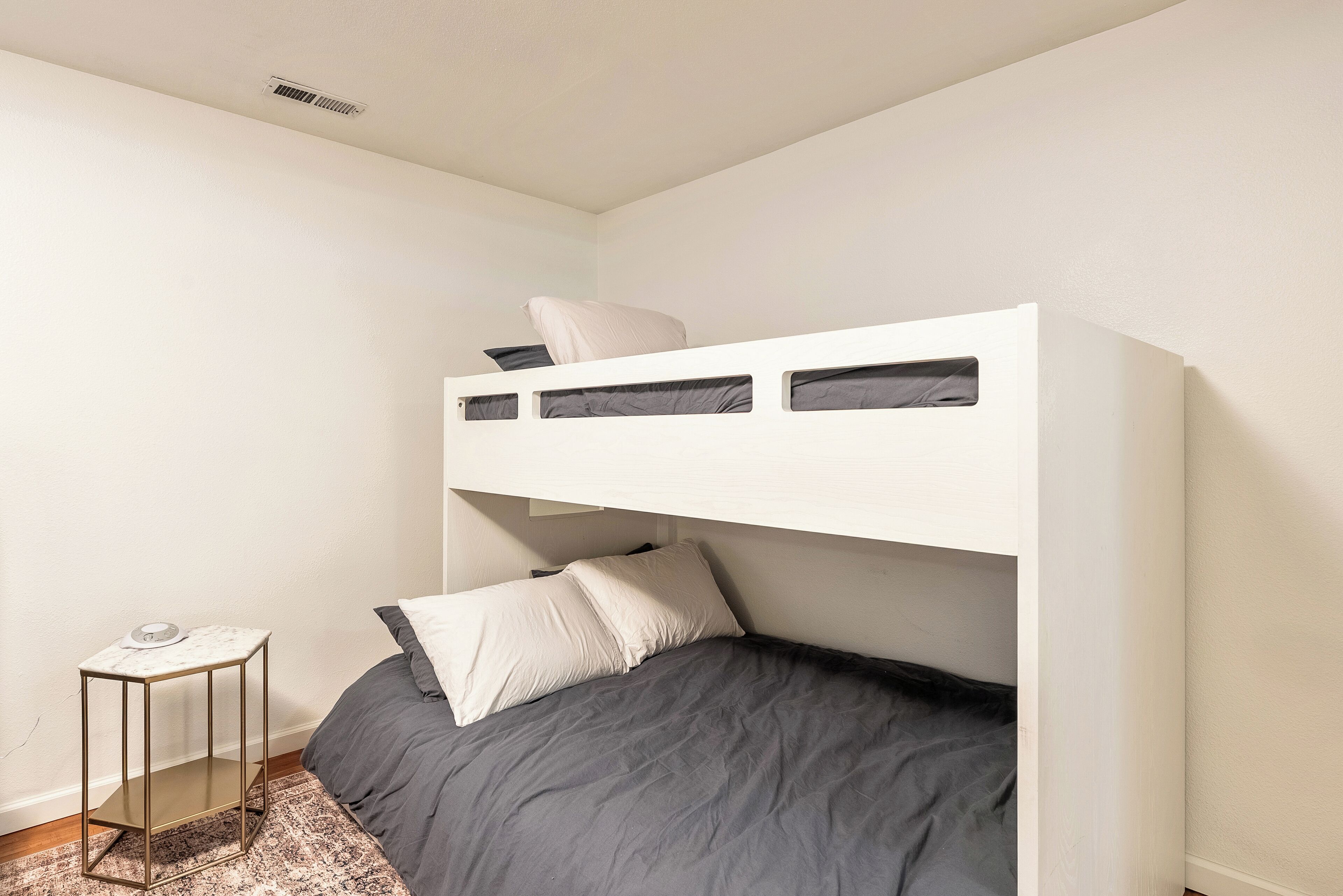 Un lit superposé avec une petite table à côté.