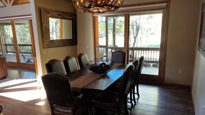 A dining area with a wooden table, leather chairs, and a chandelier.
