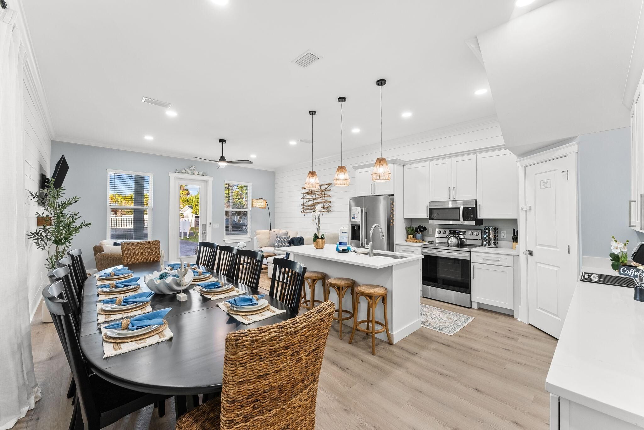 A modern kitchen with white cabinets, a central island, and pendant lighting.