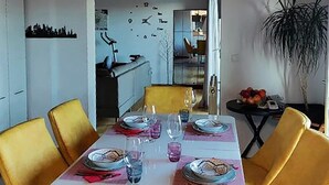 A dining area with a table set for four, yellow chairs, and a small side table with fruits. - 3 bedroom beautiful apartment in Barban (Barban)