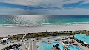 Een resort met een groot zwembad, een strand en uitzicht op de oceaan.
