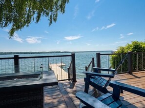 Une terrasse en bois avec une rambarde, un banc et une vue sur un lac.