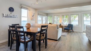 Een modern interieur met een eethoek, een bank en uitzicht op het omliggende landschap.