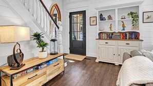 Amplia sala de estar con una mesa de centro de madera, una estantería y un sofá blanco.