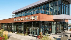Un bâtiment moderne doté d’une grande façade en verre et sur lequel on peut clairement lire l’inscription « Harbour Master ».