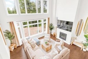 Ein geräumiges Wohnzimmer mit einer großen Eckcouch, einem Couchtisch und einem Kamin.