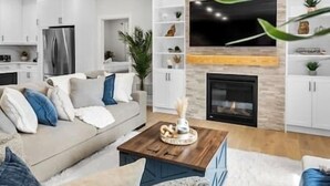 Ein modernes Wohnzimmer mit Sofa, Couchtisch und Kamin.