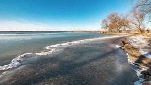 Un río congelado con hielo transparente y un puente a lo lejos.