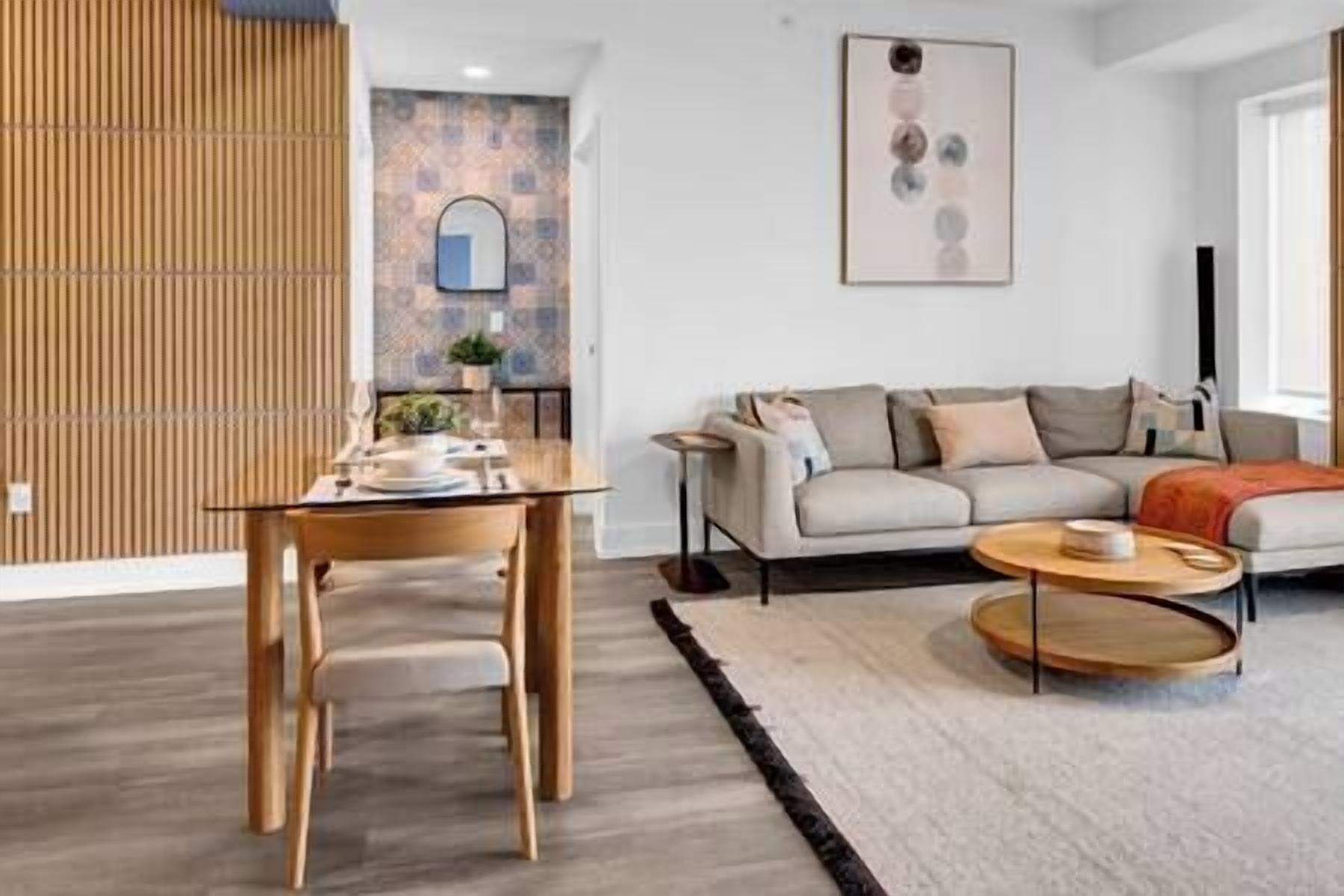 Een moderne woonkamer met een houten eettafel, een bank en een bijzettafeltje.