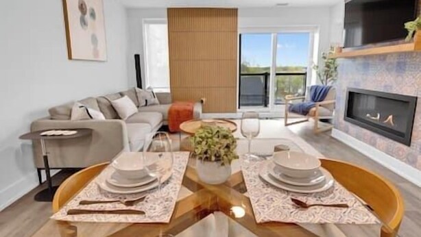 Una sala moderna con sofá, mesa de comedor para dos personas y chimenea.