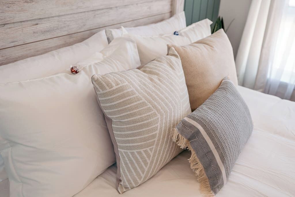 Un lit avec plusieurs oreillers et une couverture.