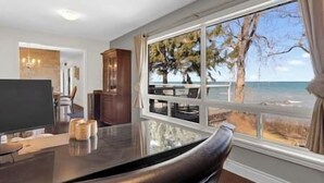 Ein modernes Wohnzimmer mit großem Fenster mit Blick auf einen Strand.