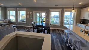 Une cuisine moderne avec un coin repas, de grandes fenêtres et une vue sur le quartier.