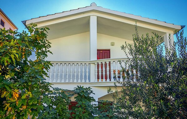 A two-story building with a balcony, white walls, and a red door. - 1 bedroom amazing apartment in Vodice (Vodice)