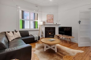 A living room with a fireplace, a sofa, a television, and a coffee table.