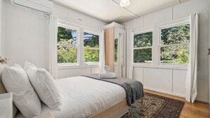 Una camera da letto con un letto, una finestra e vista su del verde.