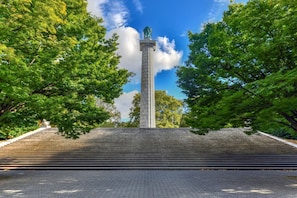 A monument with a tall column and steps leading up to it, surrounded by trees. - Spacious Fort Greene 1-Bed (Brooklyn)