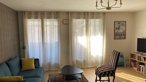 A living room with a sofa, armchair, coffee table, and a bookshelf. - MAISON GERMÈS - CENTRAL & STANDING, parking nearby, bed linen included (Bagnères-de-Luchon)