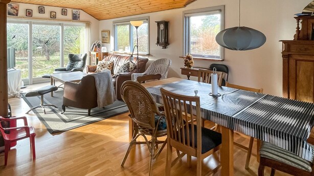 A cozy living room with a wooden ceiling, a dining table, and comfortable seating. - 2 bedroom beautiful home in Orø (Orø)