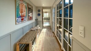 A hallway with a bench, a rug, and a large window with multiple panes. - Beautiful home in Nykøbing Sj with sauna (Nykøbing Sj)