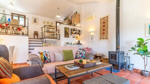 Un salon chaleureux avec un canapé, des fauteuils, une table basse et une cheminée.
