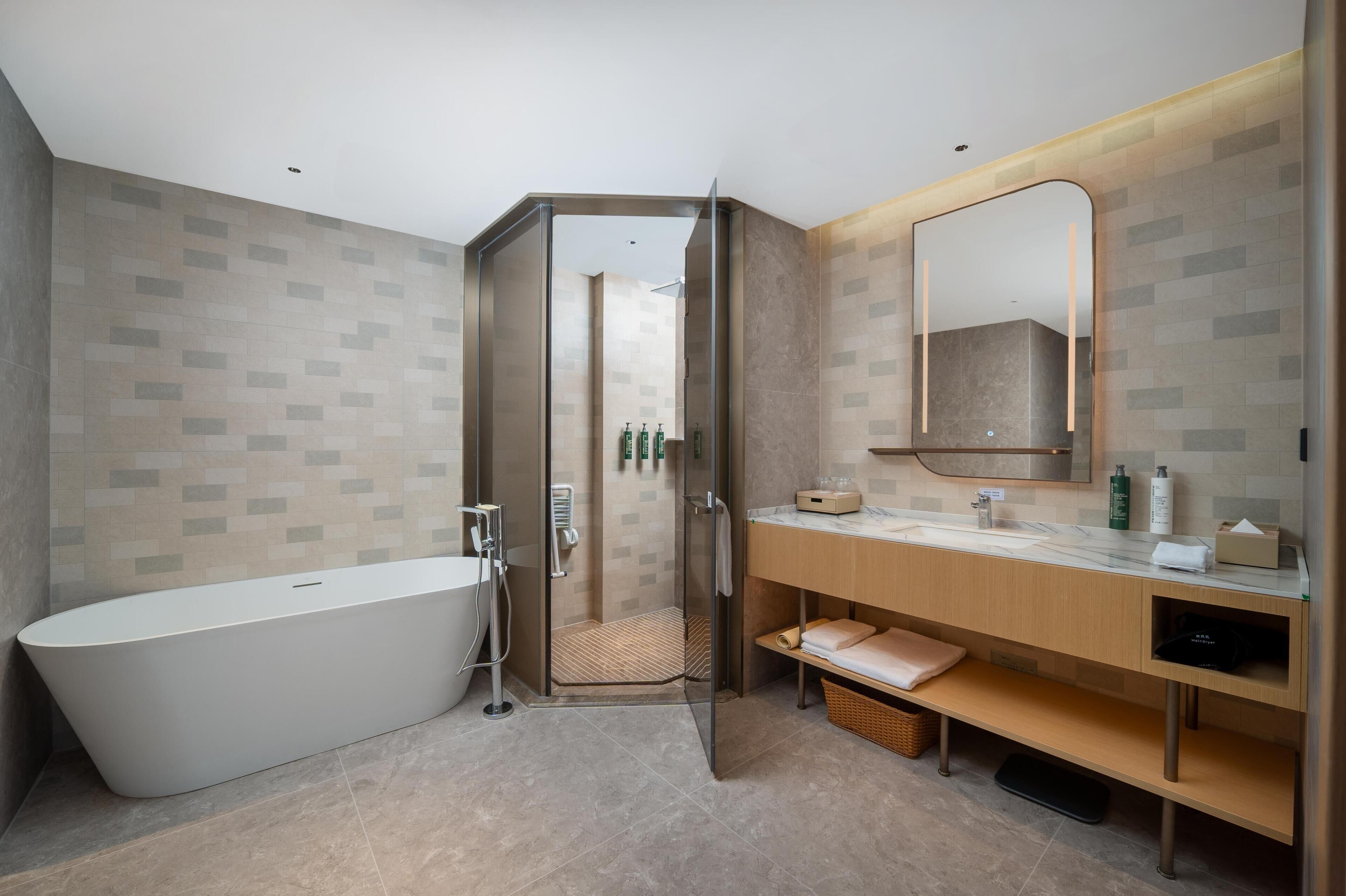 A modern bathroom with a freestanding bathtub, a glass-enclosed shower, and a vanity with a mirror.