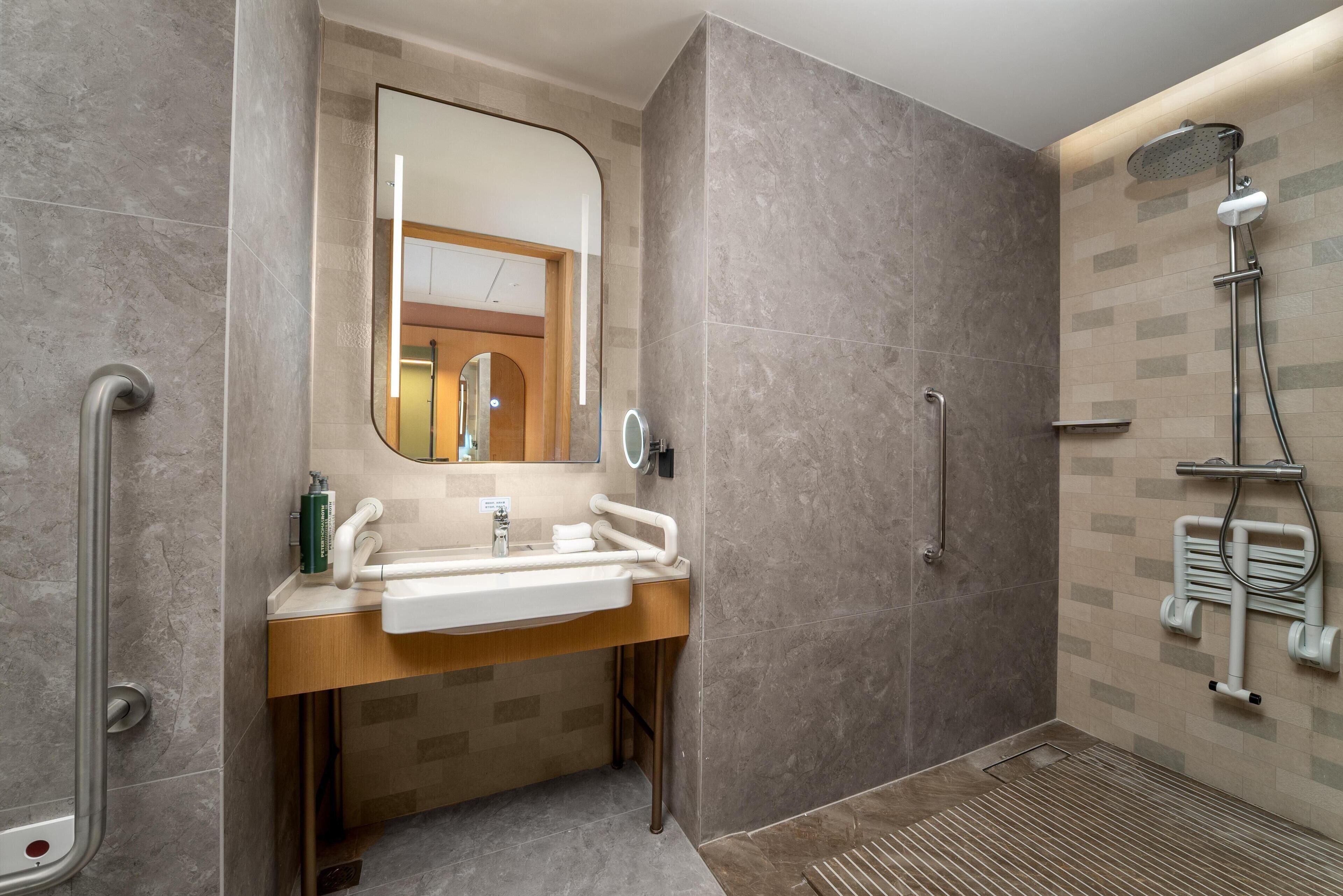 Ein modernes Badezimmer mit Waschbecken, Spiegel und Dusche.