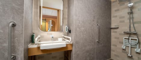 Ein modernes Badezimmer mit Waschbecken, Spiegel und Dusche.