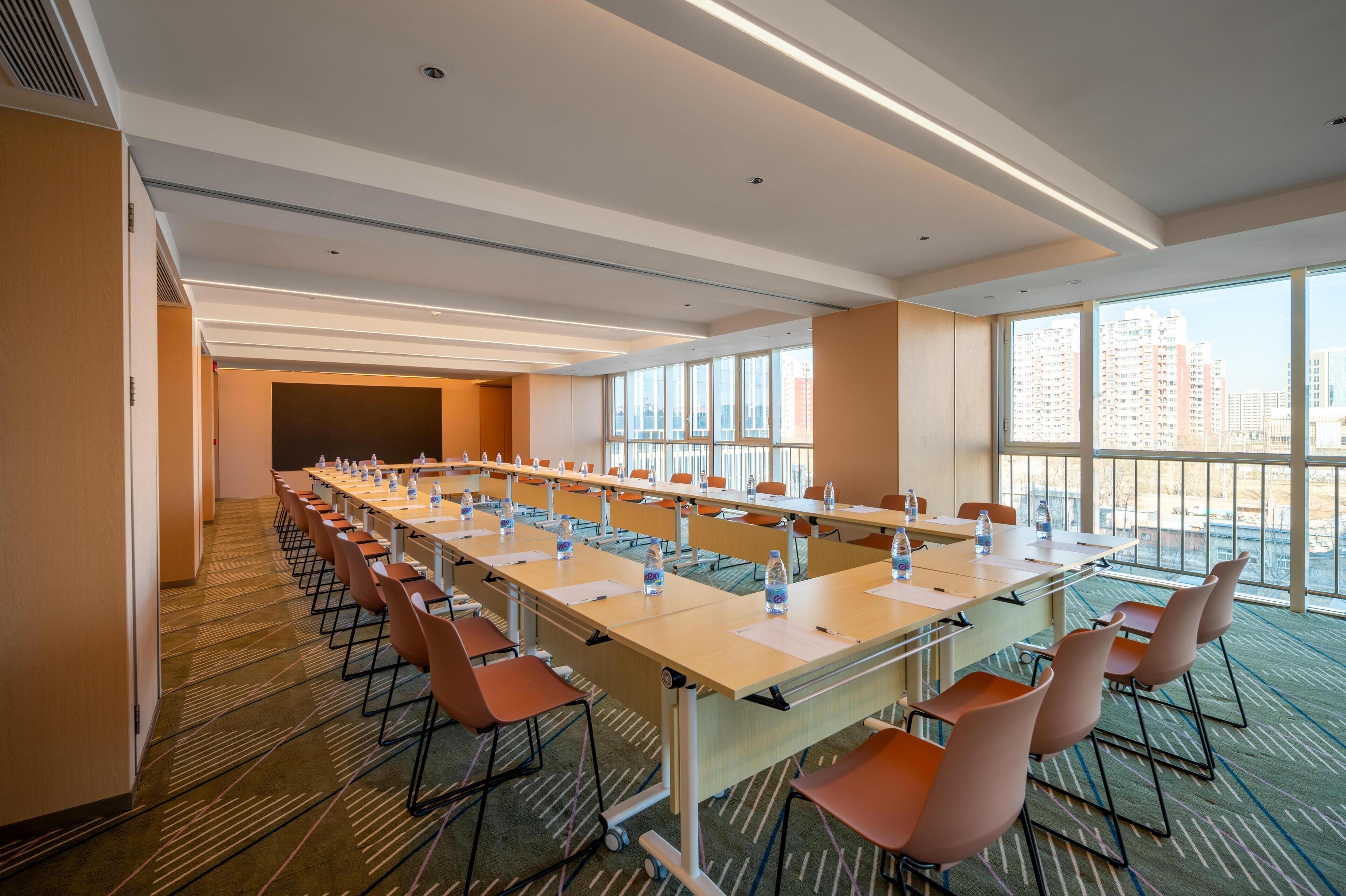 A conference room with a long table, chairs, and water bottles.
