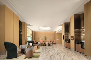 A hotel lobby with seating, a reception desk, and a large window. - Hilton Garden Inn Hangzhou Fuyang Fuchun (Hangzhou)