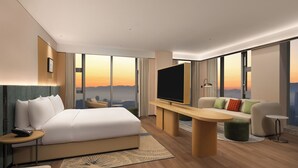 A modern hotel room with a large bed, a flat-screen TV, a sofa, a desk, and a large window offering a city view. - Hilton Garden Inn Hangzhou Fuyang Fuchun (Hangzhou)