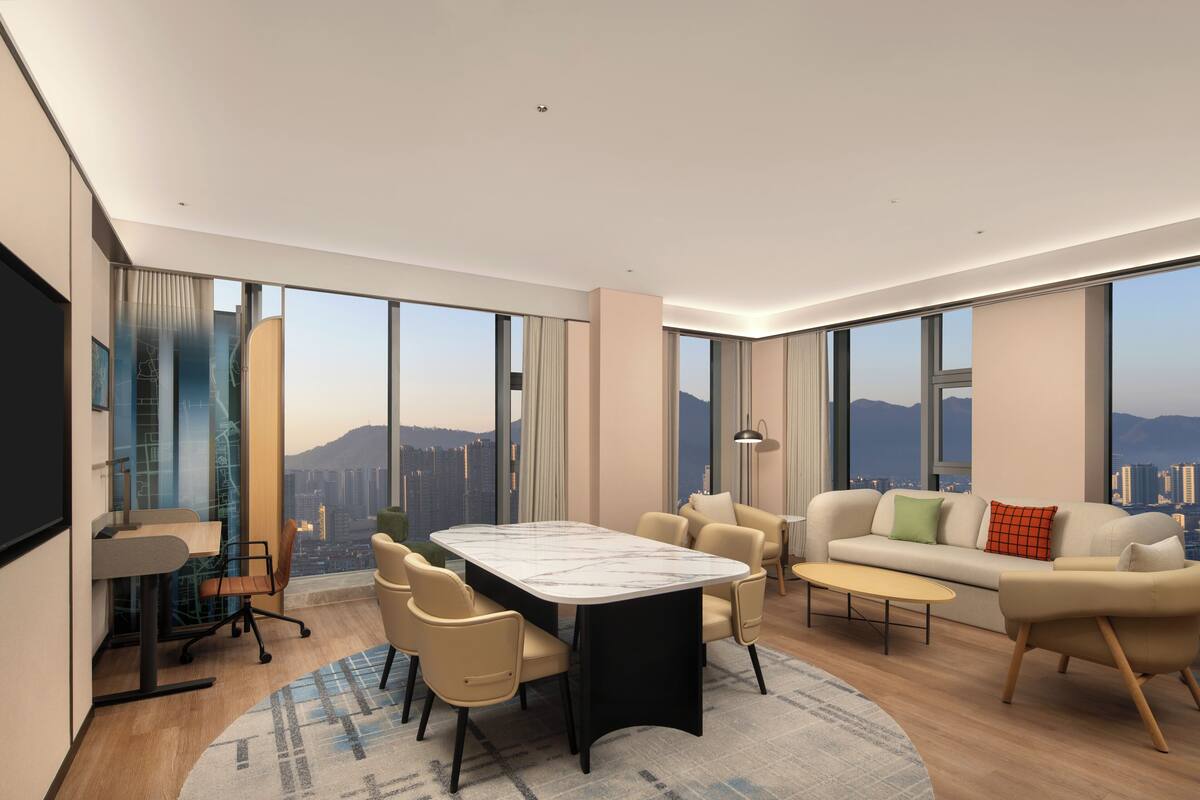 Ein modernes Wohnzimmer mit Essbereich, großen Fenstern und Blick auf die Stadt.