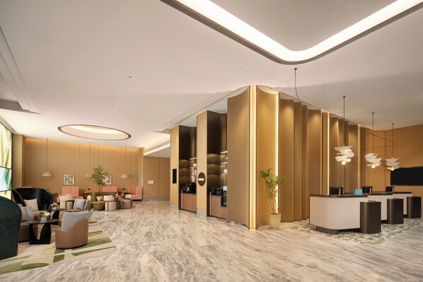 A modern hotel lobby with seating areas, a reception desk, and a reception area. - Hilton Garden Inn Hangzhou Fuyang Fuchun (Hangzhou)