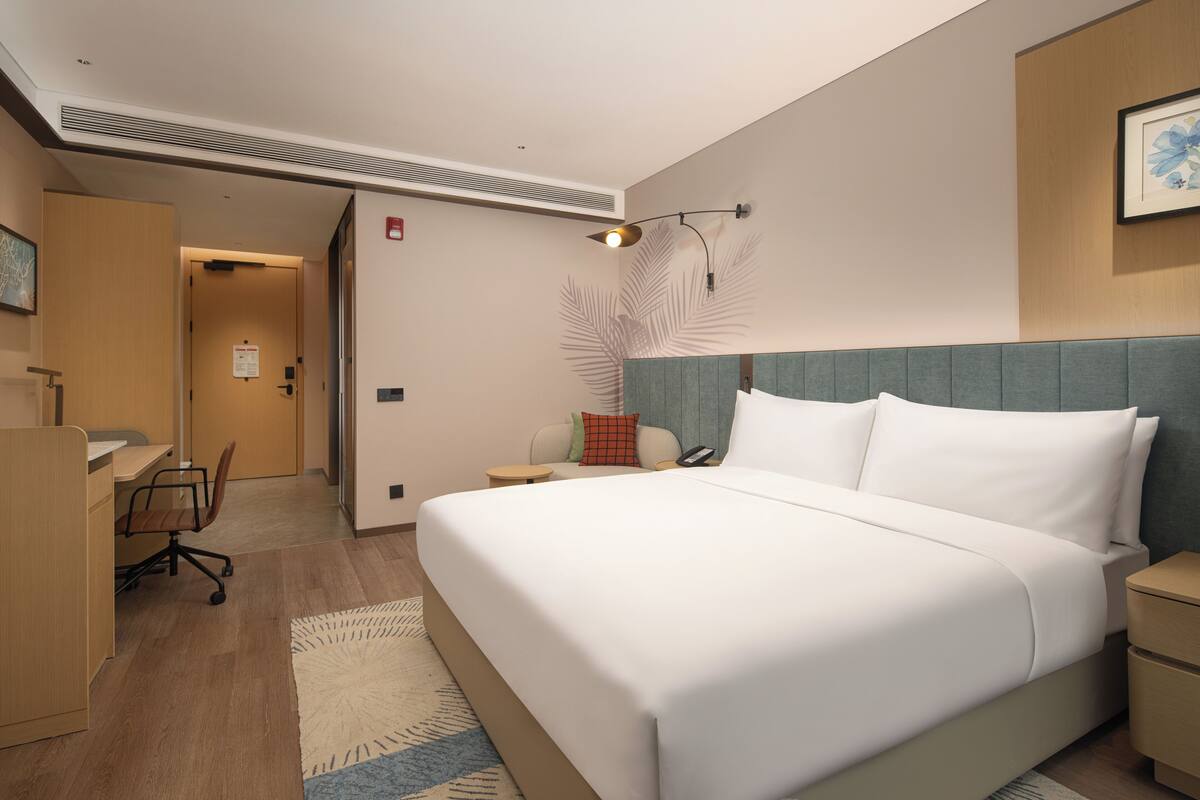 Ein Hotelzimmer mit Bett, Schreibtisch, Stuhl und einem kleinen Tisch.