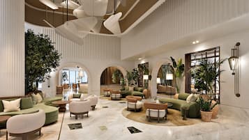 A spacious lobby with multiple seating areas, a reception desk, and large windows allowing natural light.