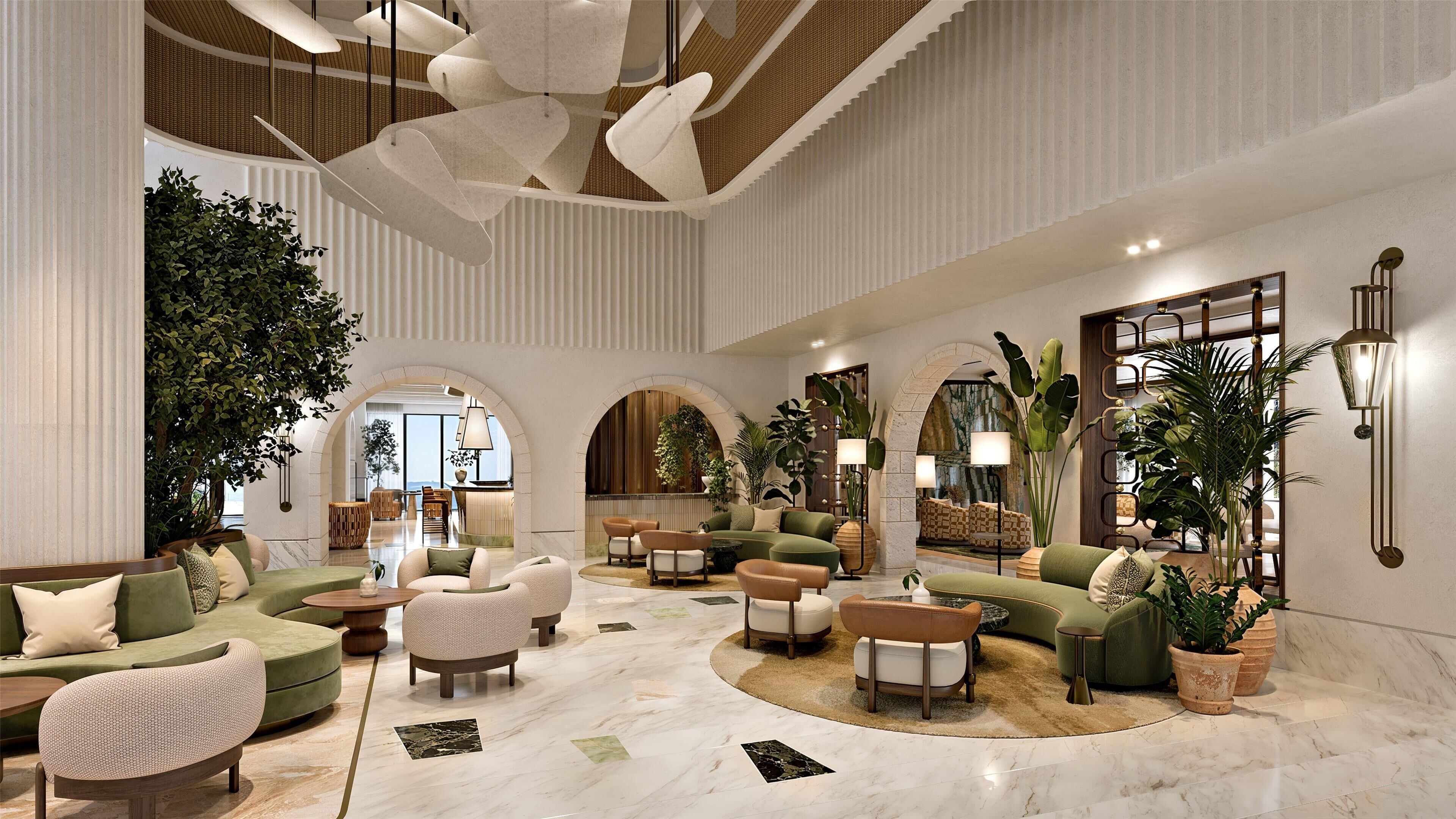 A spacious lobby with a central seating area, multiple sofas, and a large arched doorway leading to another room.