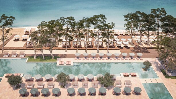 An aerial view of a resort with multiple swimming pools, sun loungers, and umbrellas. - Conrad Corfu (Corfu)