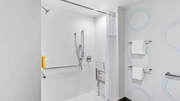 A modern bathroom with a walk-in shower, a towel rack, and a toilet.
