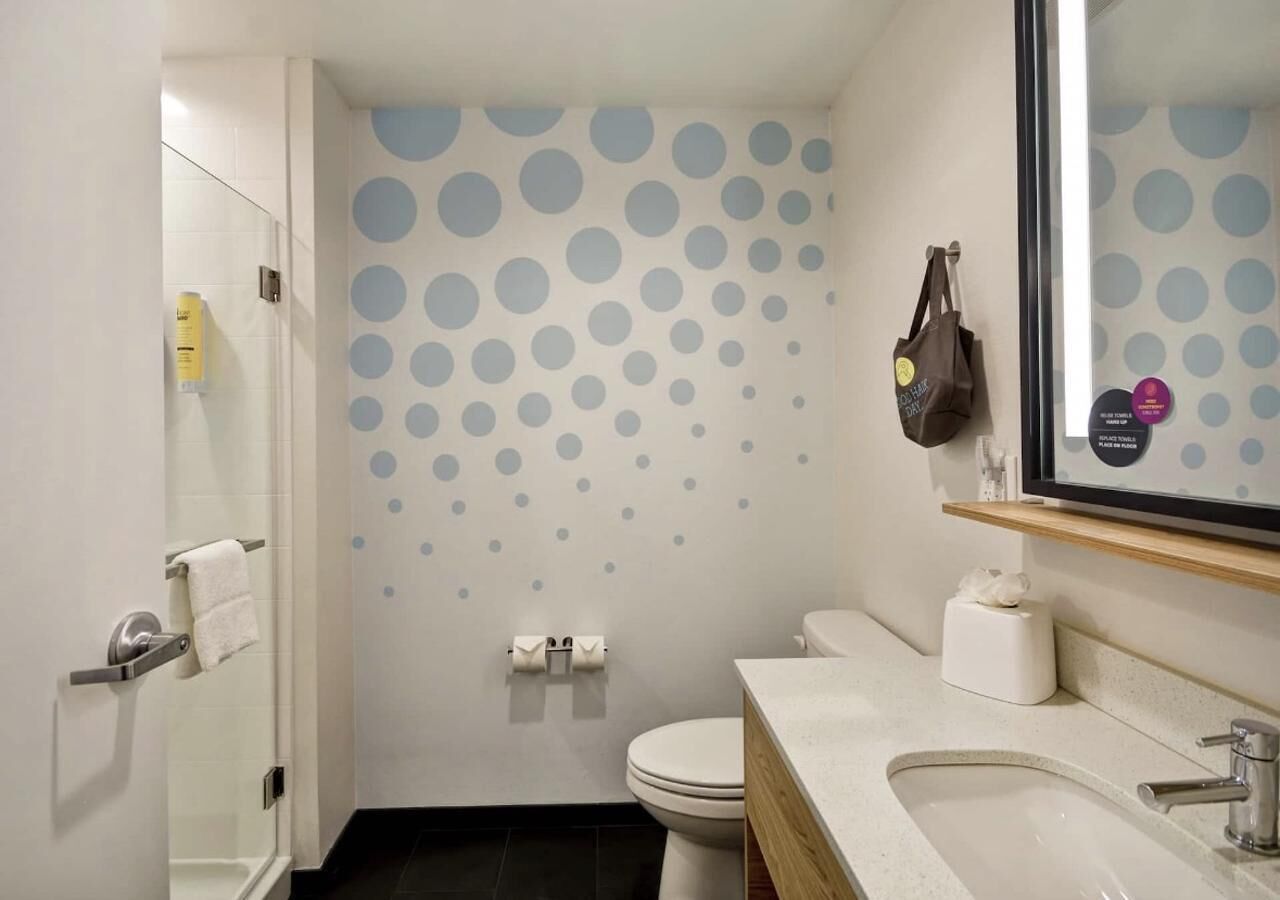 A modern bathroom with a toilet, sink, and shower.