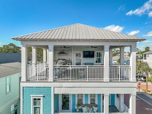A two-story house with a balcony, a covered porch, and a flat roof.