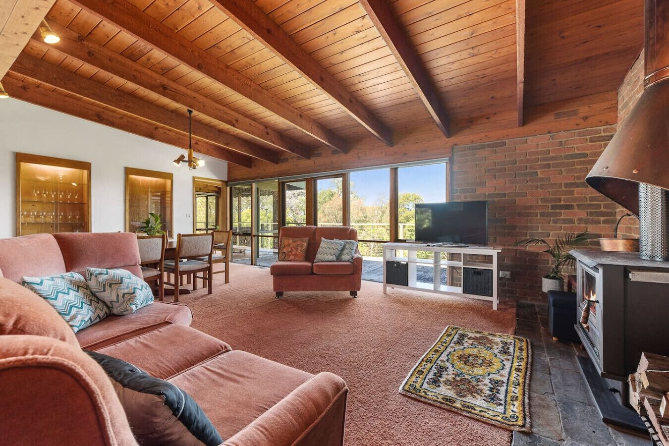 Una sala de estar acogedora con chimenea, televisor y un ventanal con vistas al exterior.