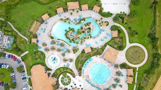 Vue aérienne d’un complexe hôtelier doté de plusieurs piscines, d’un terrain de golf et d’un parking.