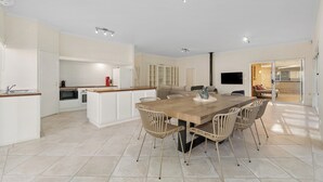A modern kitchen with white cabinets, a wooden countertop, and a built-in oven.