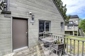 Una casa con fachada gris, una puerta principal, una ventana y el número 2166 en la pared.
