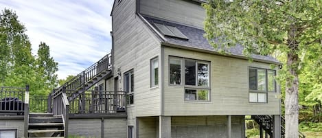 Ein modernes, zweistöckiges Haus mit einer markanten Treppe, großen Fenstern und einer Garage.