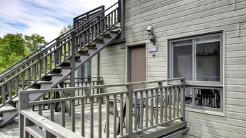 A residential building with a wooden deck, a staircase, and a door marked with the number 2166.