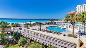 Un resort con piscina, playa y palmeras.