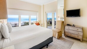 A bedroom with a large bed, a ceiling fan, a TV, a dresser, and a balcony with a view of the ocean. - 2BR Gulf-front condo w/ private balconies (Miramar Beach)