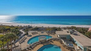 Ein Resort mit mehreren Schwimmbecken, einem Strand und freiem Blick auf den Ozean.