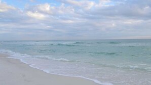 Une plage dotée d’un large rivage sablonneux et de vagues douces.